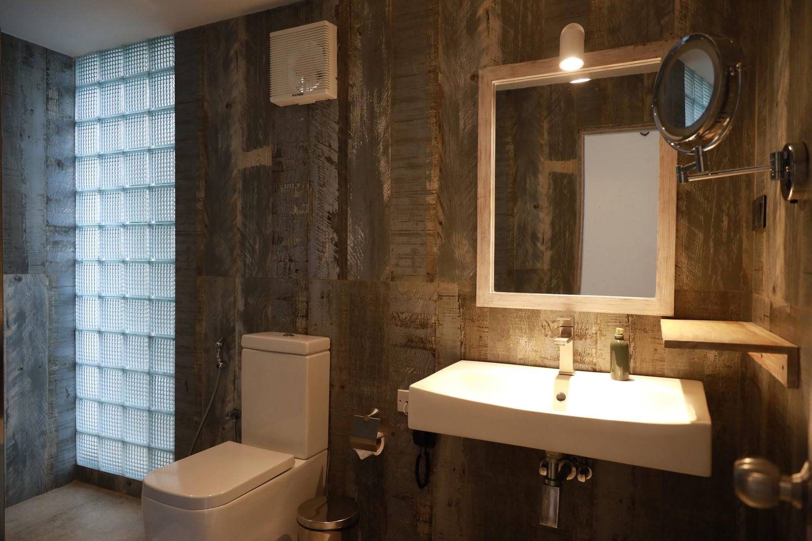Modern en-suite bathroom with rustic wood-panelled walls at The Summit Kandy